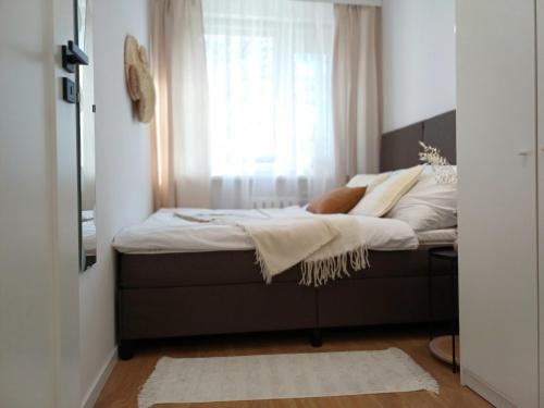 a bedroom with a bed with a window at Apartament Jadwiga in Biskupiec