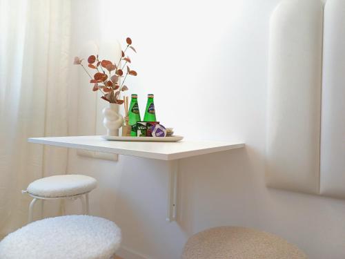 a white table with two bottles and a stool at Apartament Jadwiga in Biskupiec