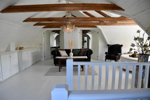 a living room with a chandelier and a kitchen at Kopperhemmets Gård in Holmared