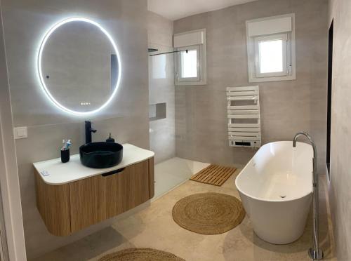 a bathroom with a tub and a sink and a mirror at El Olivo Private Swimming Pool in Mojácar