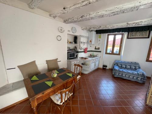 un salon avec une table et une cuisine dans l'établissement House Old town 50m beach&shop, à Menton