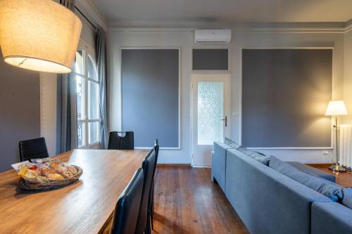 ein Esszimmer mit einem Tisch und einem blauen Sofa in der Unterkunft Indipendenza Loft City Center in Bologna