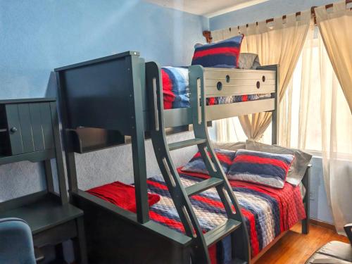 a bunk bed with a television in a bedroom at Departamento cerca de Reforma y Chapultepec - atrás Torre Mayor in Mexico City