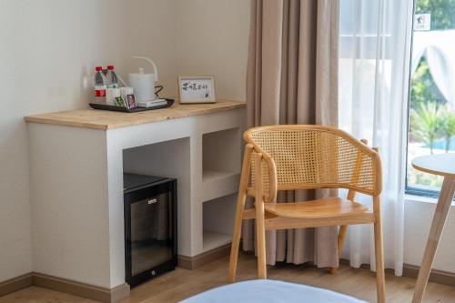 a room with a fireplace and a wooden chair at Leshan Summer Valley Mountain Stream in Leshan