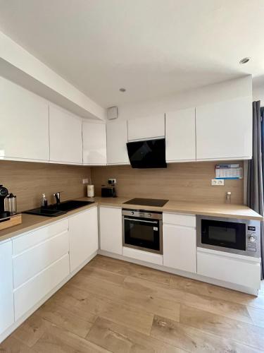 une cuisine avec des armoires blanches et un comptoir dans l'établissement April' House Neffiès, à Néffiès