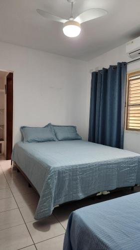 a bedroom with a large bed with blue curtains at Casa de São Pedro in São Pedro