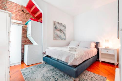 a bedroom with a bed and a brick wall at Prime Location Upper Manhattan Furnished Apartment in New York