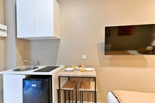 une petite cuisine avec un évier et un comptoir dans l'établissement Studio situé dans le 11ème arrondissement, à Paris