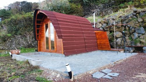 a small wooden building with a patio in a field at Recanto Terra Alta in São Roque do Pico