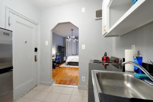 a kitchen with a sink and a hallway with a bedroom at Spacious Upper East Side Studio in New York