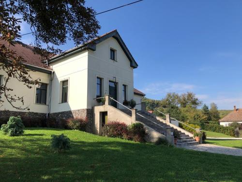 a white house with stairs in a yard at Fáy Mansion in Irota