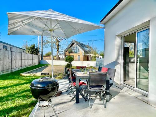 - un barbecue et une table avec un grill et un parasol dans l'établissement Le 3C - Maison Neuve - Terrasse - Jardin Clos, à Erdeven