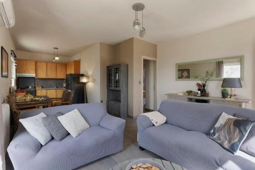 a living room with two blue couches and a kitchen at Ethos Retreat, Luxury Villas in Areopolis