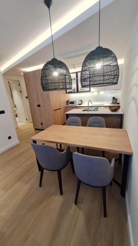 a kitchen with a wooden table and two pendant lights at Air Onia in Budva