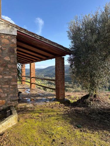 a brick building with a roof on a field at Casas Rurales Los Llanos in Fuentes de León