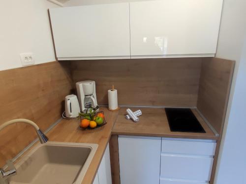 a small kitchen with a sink and fruit on a counter at Villa Mali Raj in Zaton
