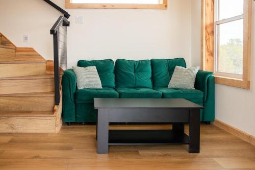 a green couch in a living room with a table at Tiny Cabin #7 at The Cedars in Kanab