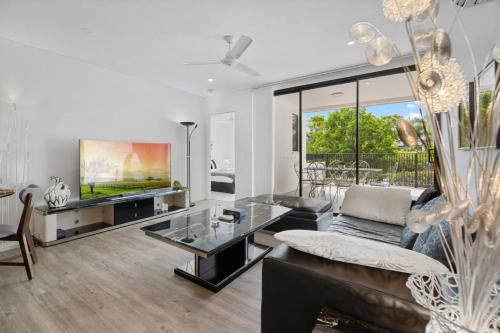 a living room with a couch and a tv at Perfect Spot Near CBD n UQ Spacious 2Beds Apt in Brisbane