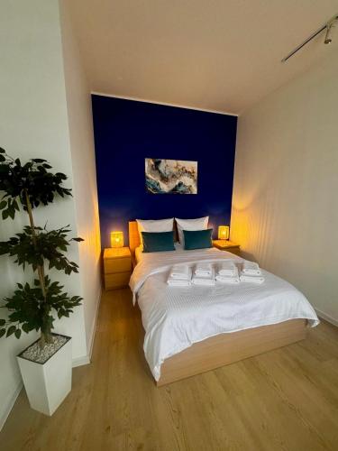 a bedroom with a large bed with a blue wall at Apartment Targowa L6 in Lublin