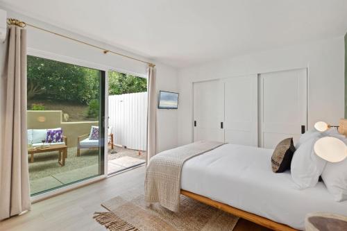 a bedroom with a bed and a sliding glass door at Seaside and Newly Renovated in Summerland