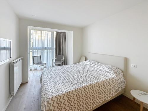 une chambre avec un lit, une table et des chaises dans l'établissement Cozy 2-bedroom apartment with terrace, sea view and parking in Cannes, à Cannes