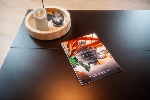 a book on a table with a candle and a box at Schloßberg - Ferienwohnung im Herzen von Selb in Selb