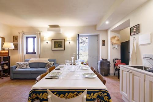 a kitchen and living room with a table and a couch at Appartamento Holly House in Radda in Chianti
