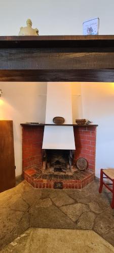 a brick fireplace with a white table on top at Villa gli Ulivi - Bariloche Lake & Mountain View in Perledo