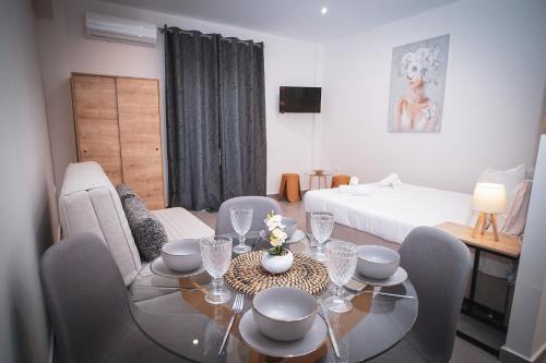 a dining room with a table and chairs and a bed at KA Luxury Apartments in Mantoúkion