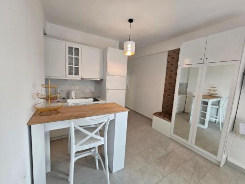 a kitchen with white cabinets and a wooden counter top at Calypso Sea View Apartament Saranda in Sarandë