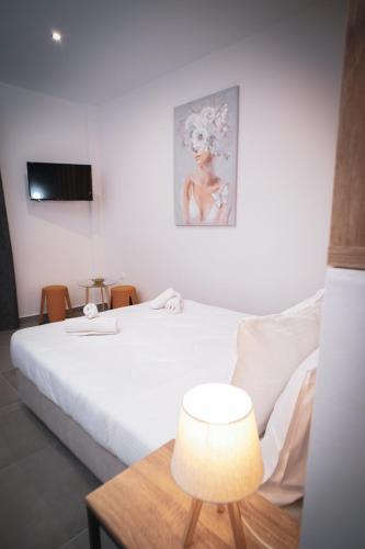 a bedroom with a bed and a table with a lamp at KA Luxury Apartments in Mantoúkion