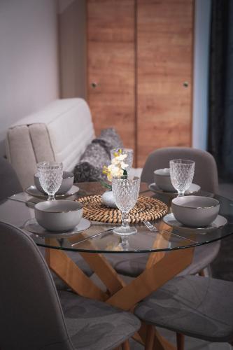 a dining room table with glasses on top of it at KA Luxury Apartments in Mantoúkion