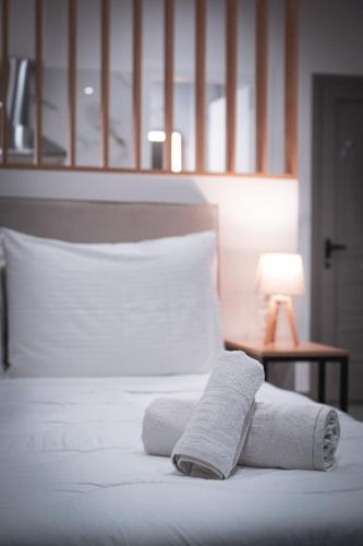 a bed with two towels on it with a lamp at KA Luxury Apartments in Mantoúkion