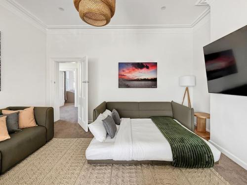 a living room with a bed and a couch at Serviced Luxury Condo, Parkside, moments to metro in Sydney
