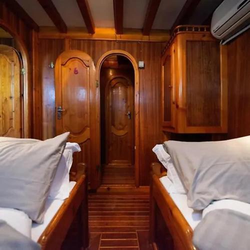 a small room with two beds and a door at Il Caicco B&B in Rodi Garganico