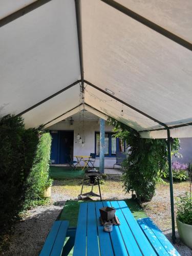a blue picnic table under a tent in a yard at Mon Jacuzzi privé sur les pas de Compostelle in Saint-Léonard-de-Noblat