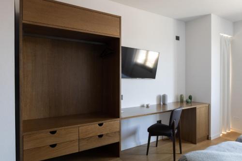 a bedroom with a large wooden cabinet with a desk at Hotel Ristorante Da Politano in Boves