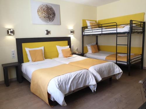 two beds in a room with two bunk beds at Hôtel Restaurant Aux Deux Roses in Neuf-Brisach