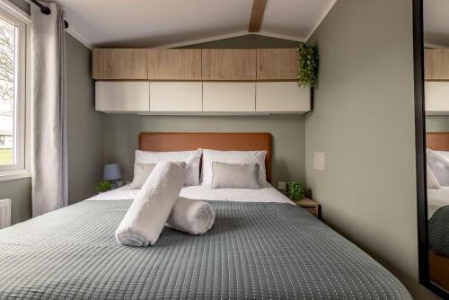 una camera da letto con un letto grande con cuscini bianchi di Lodge No 126 Stewart's Resort Cameron a St Andrews