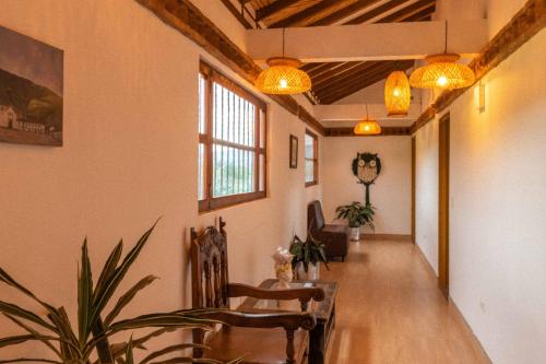 a living room with a table and chairs and lights at Artemisa Hotel Villa de Leyva in Santa Sofía