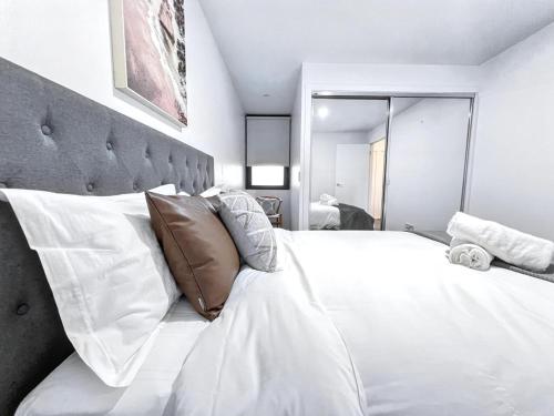 a bedroom with a large white bed with pillows at Essendon North with Beautiful view in Melbourne