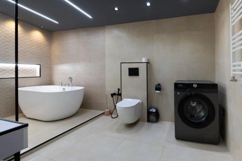 y baño con bañera y lavadora. en The Sakartvelo House - Historic Soul and Modern Luxury, en Tiflis