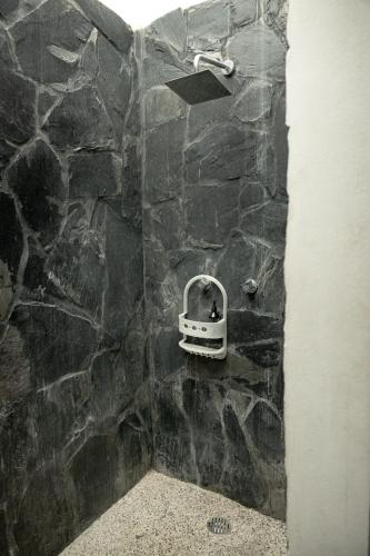 a bathroom with a stone shower with a stone wall at Casa Diego Unique Ecological / Minimalist House & Inside Pool in Brisas de Zicatela