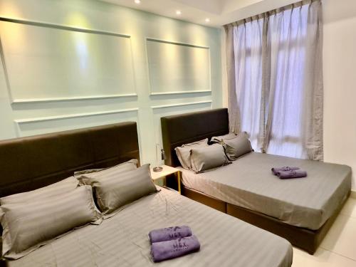 two beds in a room with purple pillows on them at KSL City Mall 6-20pax Private Lift-Netflix-SmartTV 70inch in Johor Bahru