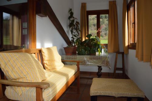 a living room with a couch and a table and window at Posada El Hoyal in Pesaguero-La Parte