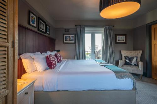 a bedroom with a large white bed and a chair at The Mayflower in Lymington