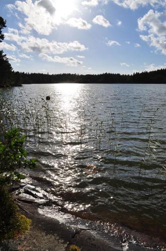 a large body of water with the sun reflecting on it at Hinders Cottages in Nauvo