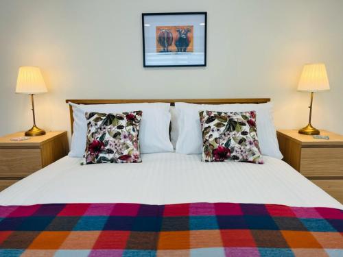 ein Schlafzimmer mit einem Bett mit Kissen und zwei Lampen in der Unterkunft Viewforth Studio No.2 in Fort William
