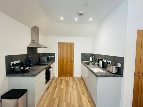a kitchen with white walls and a wooden floor at Viewforth Studio No.4 in Fort William