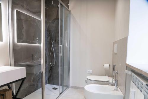 a bathroom with a shower and a toilet and a sink at Giardini Rooms in Cremona